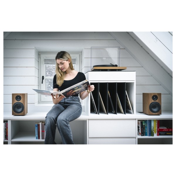 Pro-Ject Colourful Audio System 2, Walnut - Lifestyle Image Browsing vinyl art and listening to music