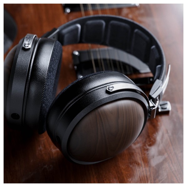 FiiO FT1 32Ω Closed-Back Headphones, Black - Lifestyle image, comparing solid wood earcup to guitar