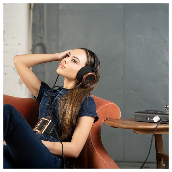 Grado Signature S950 Open-back Headphones, Brazilian Walnut - woman on orange sofa 
