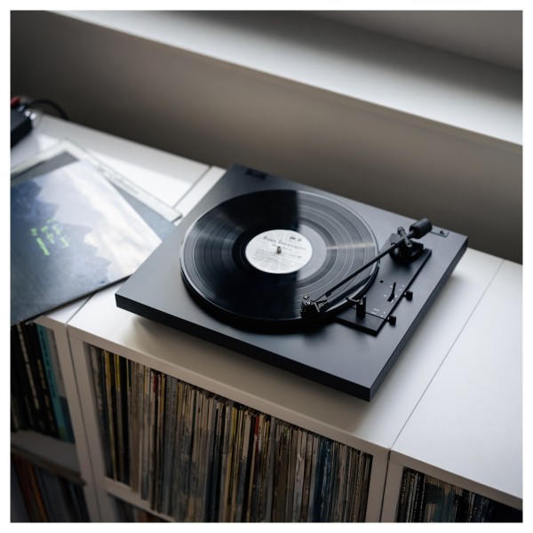 Pro-Ject A1.2 Fully Automatic Turntable, Black - Lifestyle Image with vinyl collection