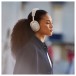 Bowers & Wilkins Px7 S3 Wireless Headphones, Vintage Champagne - Lifestyle image, commute, worn by woman