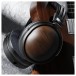 FiiO FT1 32Ω Closed-Back Headphones, Black - Lifestyle image, hanging from walnut guitar