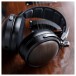 FiiO FT1 32Ω Closed-Back Headphones, Black - Lifestyle image, comparing solid wood earcup to guitar