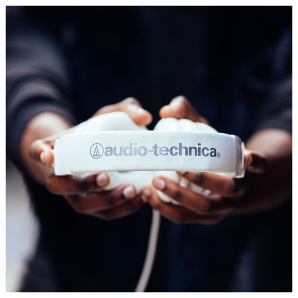 Audio Technica ATH-M50xWH Professional Monitor Headphones, White - holding headphones